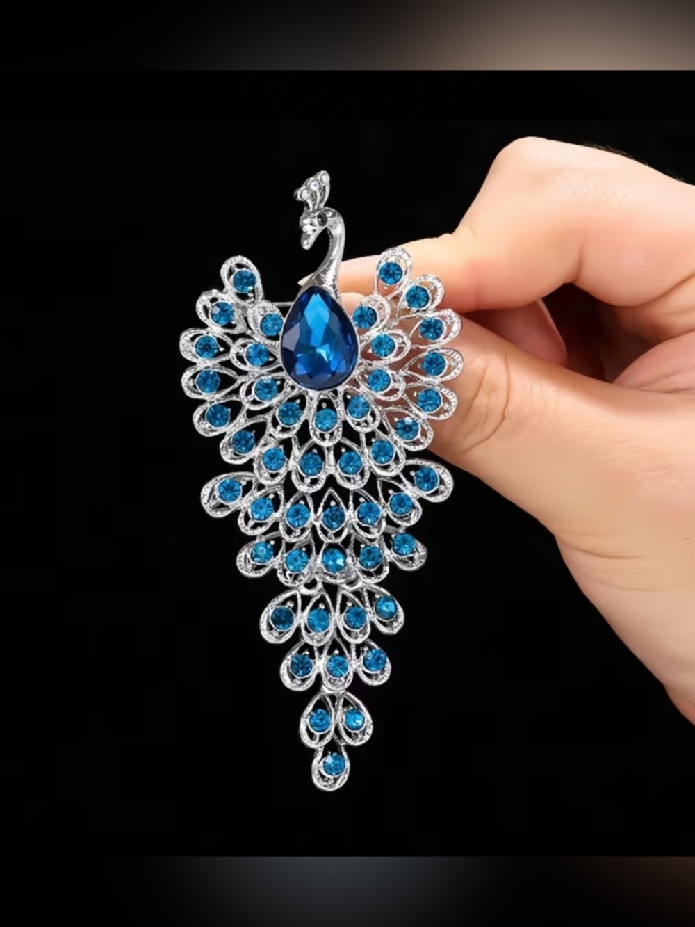 sparkling peacock-shaped statement brooch featuring blue crystals silver-tone